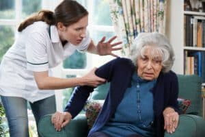 Caregiver mistreating scared senior at nursing home.